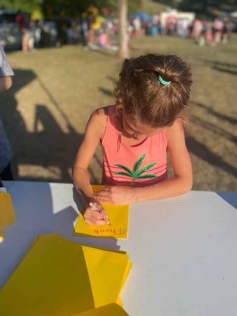 a young girl writing on a card