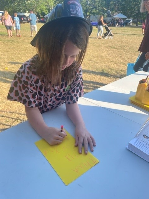 a young girl writing on a card