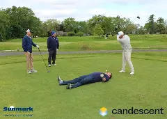 A team posing for a picture on the green