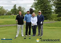 A team posing for a picture on the green